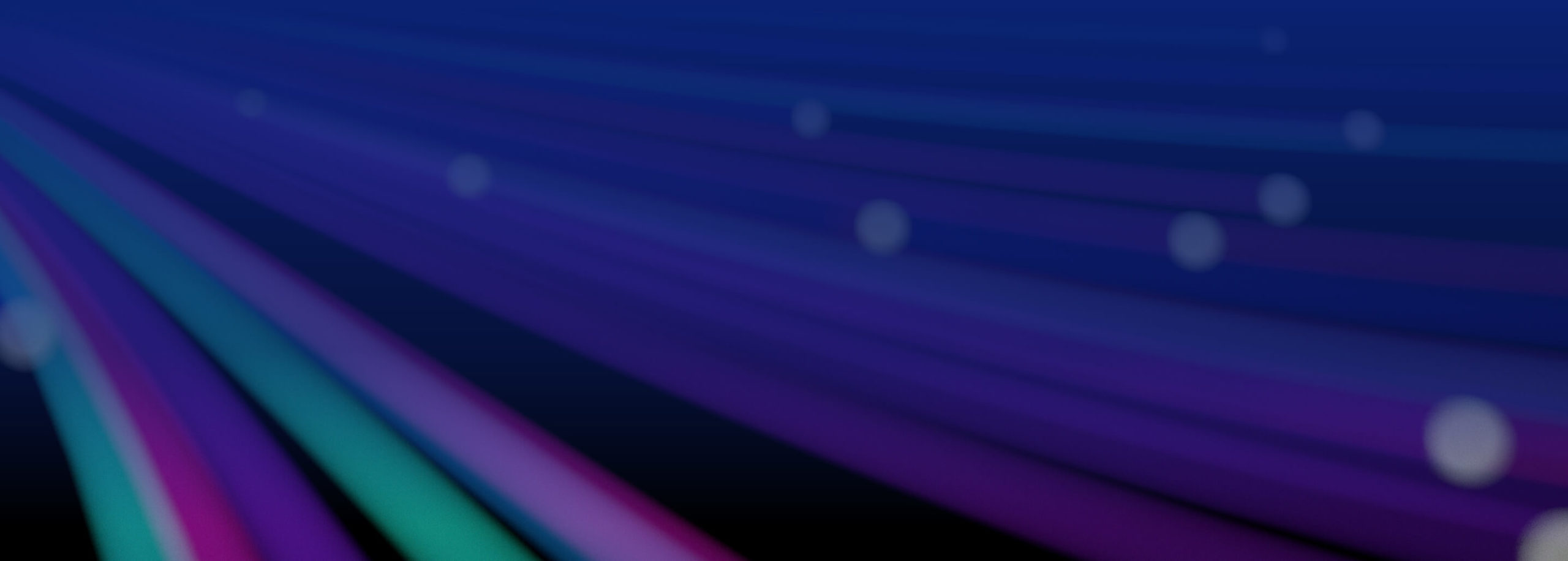 Close, out of focus image of abstract glowing spiral lines of bright purple, green and blue.