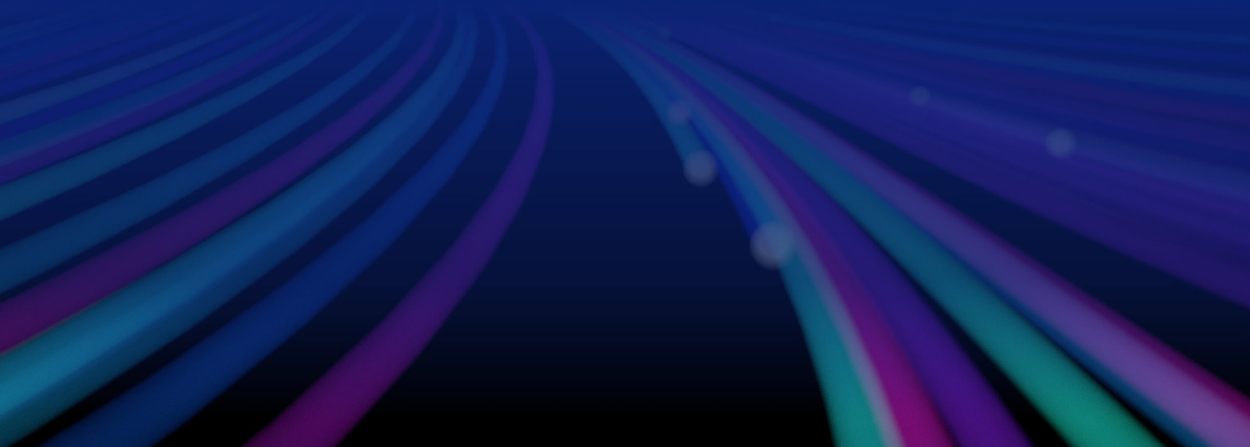 Zoomed out, unfocused image of abstract glowing spiral lines of bright purple, green and blue.